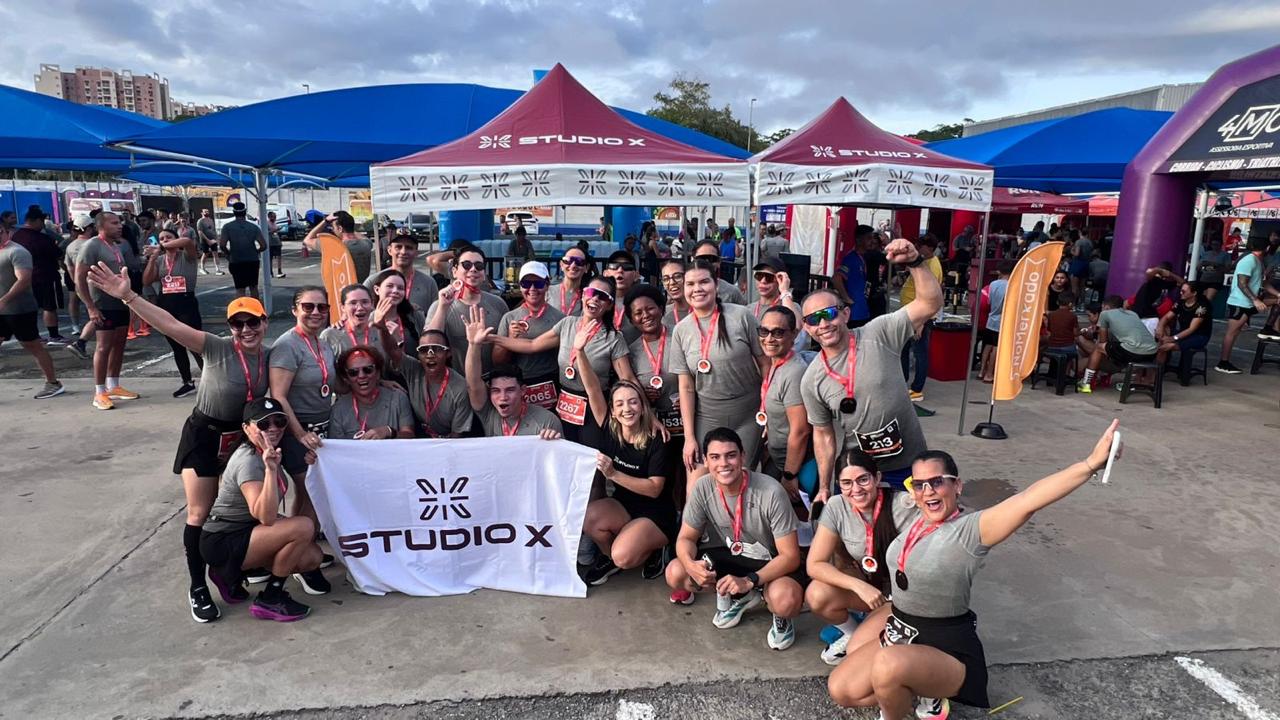 Equipe Studio X reunida com a bandeira após uma prova de rua